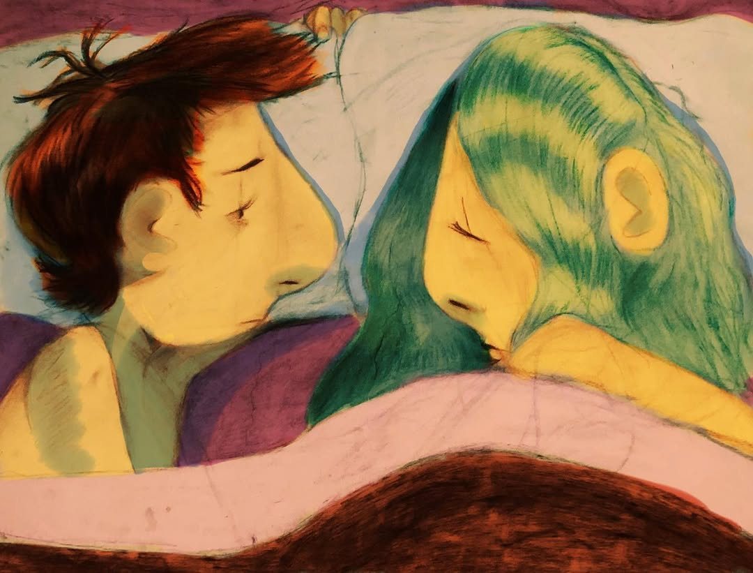 Two people lying face to face under a blanket, one with green hair