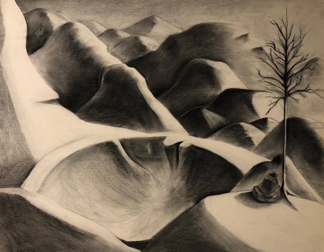 Charcoal landscape of folded hills with a single bare tree